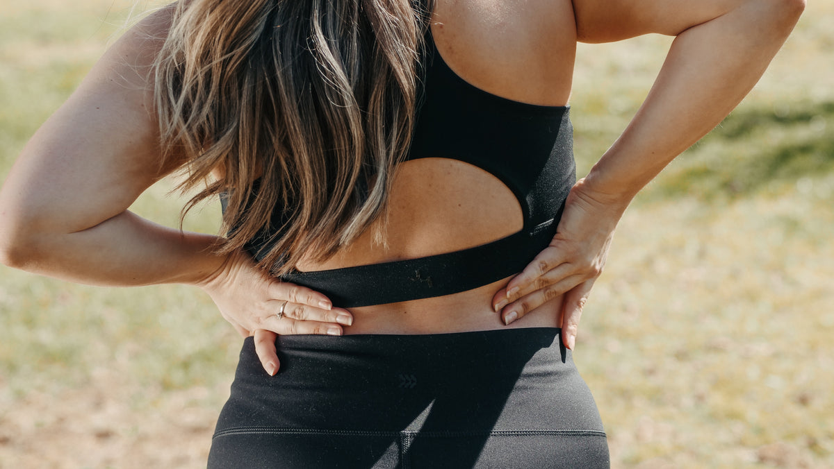 woman touching her lower back