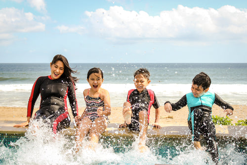 mom with children kicking feet in water